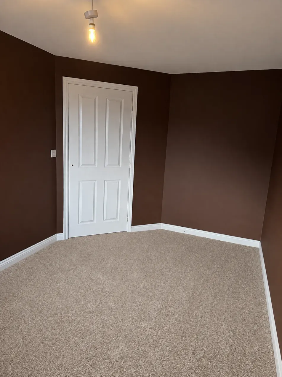 Bedroom walls painted chocolate brown with white woodwork