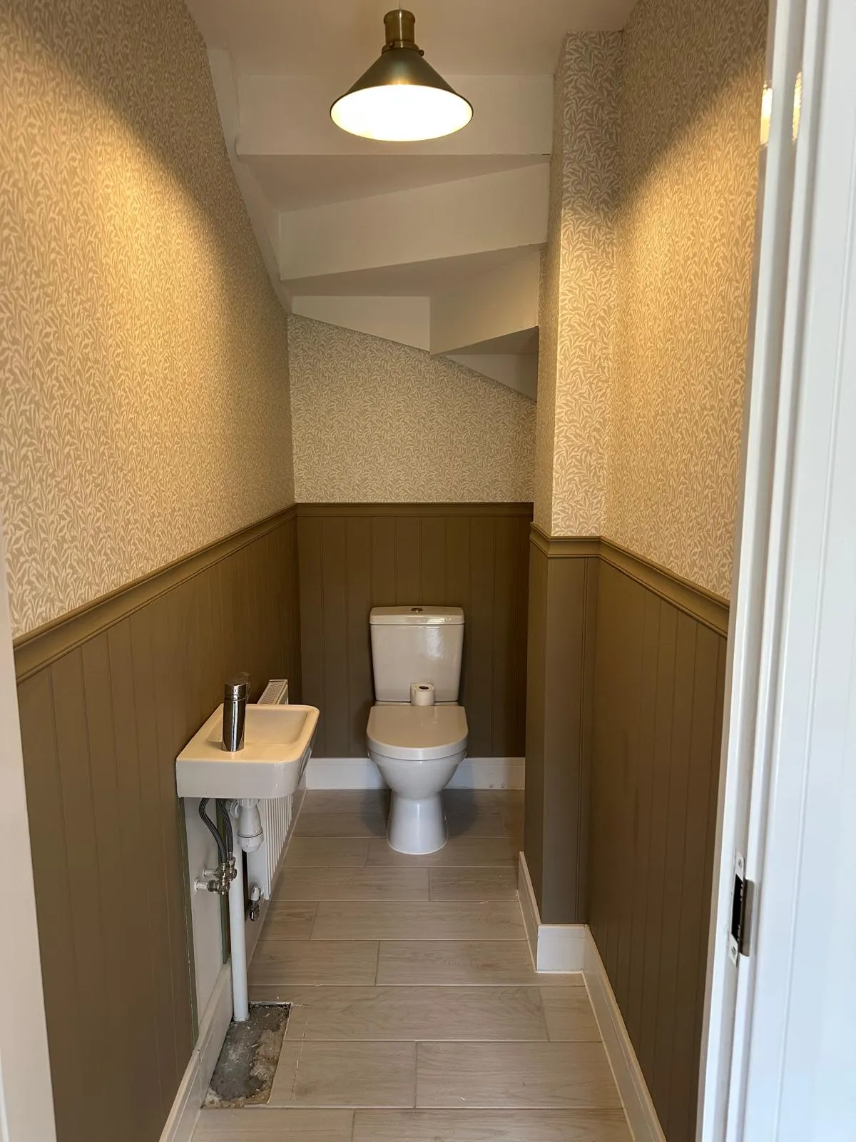 Cloakroom with painted panelling and feature wallpaper