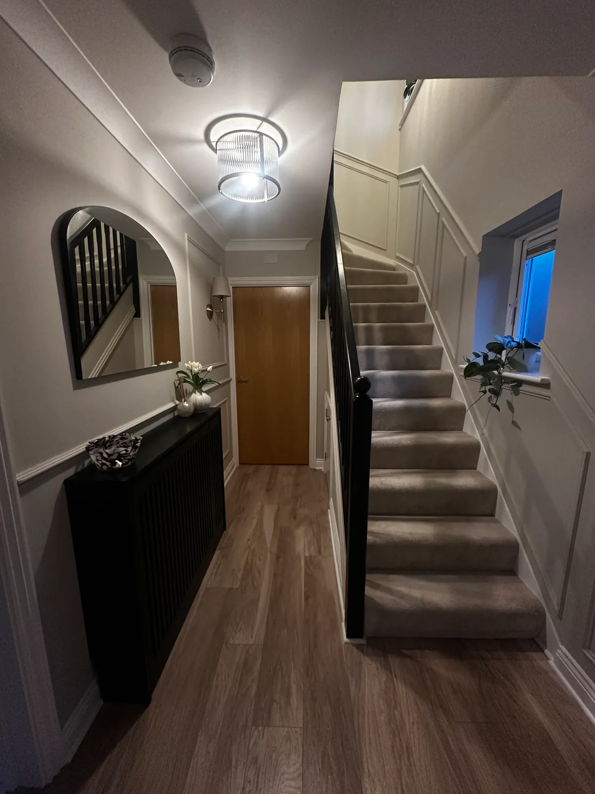 Panelled hallway and staircase at dusk