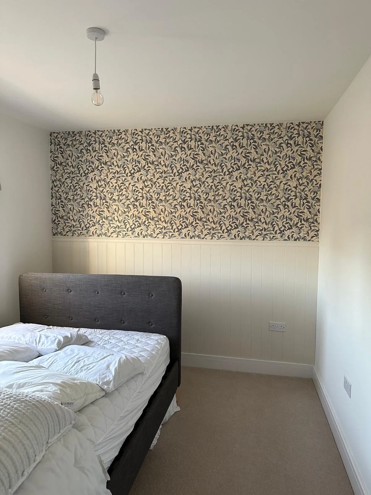 Bedroom with tongue and groove panelling and feature wallpaper